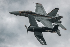 An F4U Corsair and F/A-18 Super Hornet make a side by side pass for the crowd