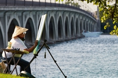 An artist sets her canvas on the MacArthur Bridge connecting Detroit to Belle Isle